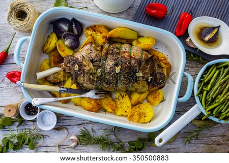 Lamb meat - roasted leg of lamb with rosemary, spices and roasted potatoes
