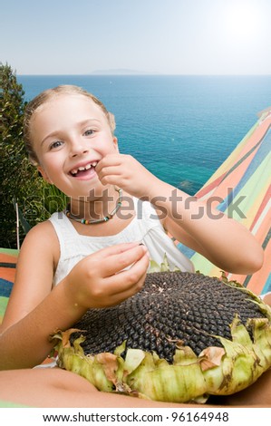 Summer - Girl in hammock with the seeds of the sunflower