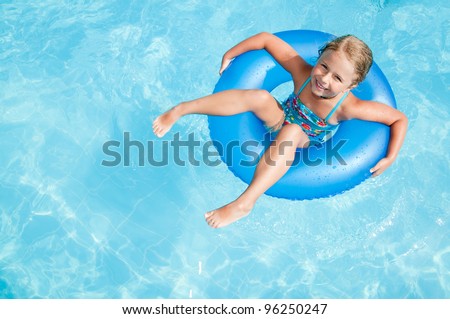 Swimming, summer vacation - lovely girl playing in blue water (space for text)