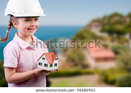 Family house concept  - Outdoor portrait of lovely girl with house model