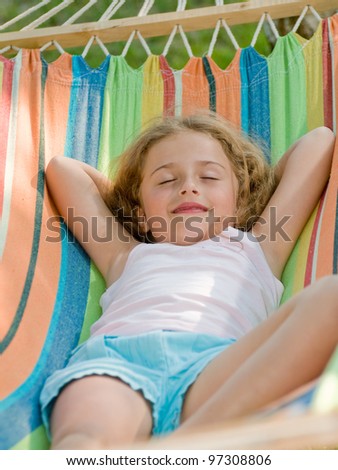 Summer holiday - lovely girl in colorful hammock