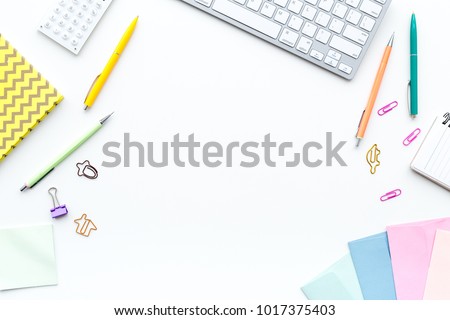 Creative mess on student\'s desk. Keyboard, notebook, stationery, on white background top view copy space