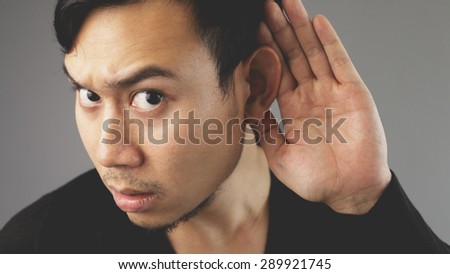 Trying to listen to you with his hand on his ear.