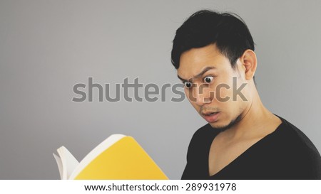 A man surprised the content in the yellow book.
