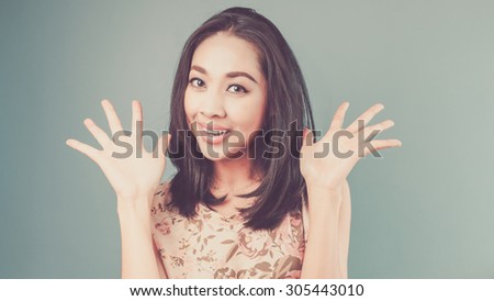 Surprise content. Vintage, retro style of portrait of Asian woman in pink vintage dress on blue - green background.