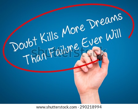 Man Hand writing Doubt Kills More Dreams Than Failure Ever Will with black marker on visual screen. Isolated on blue. Business, technology, internet concept. Stock Image