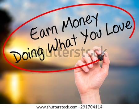 Man Hand writing Earn Money Doing What You Love with black marker on visual screen. Isolated on nature. Health, technology, internet concept. Stock Image