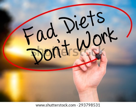 Man Hand writing Fad Diets Don\'t Work with black marker on visual screen. Isolated on nature. Business, technology, internet concept. Stock Photo