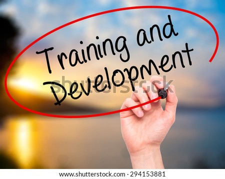 Man Hand writing Training and Development with black marker on visual screen. Isolated on nature. Business, technology, internet concept. Stock Photo