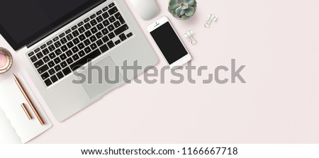bright feminine banner / header with a stylish workspace with laptop computer, smartphone modern office accessories and a small succulent on a blush table, top view / flat lay