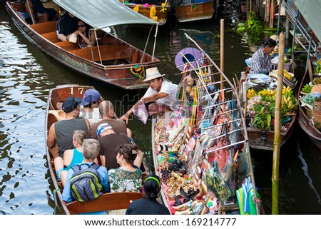 RATCHABURI,THAILAND - Oct 18 : Tourist buying souvenir from local merchant at Damnoen Saduak floating market,on Oct 18, 2013 in Ratchaburi,Thailand .Dumnoen Saduak is a very popular attraction.