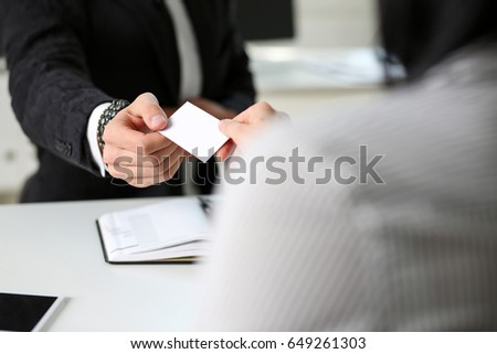 Male hand in suit give blank calling card to female visitor closeup. White collar partners company name exchange, executive or ceo introducing at conference, product consultant, sale clerk concept