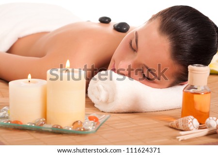 Attractive woman getting spa treatment isolated on white background. Hot Stones Massage