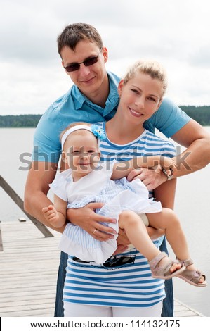 Happy family on the river bank
