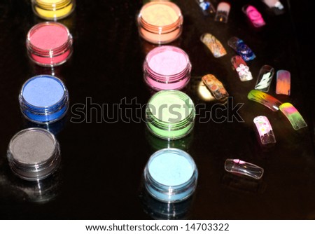 Set of powder cosmetic and fake nails on a mirror table (shallow dof)