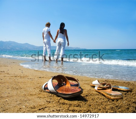 Two People Holding Hands On The Beach. at the each holding hands