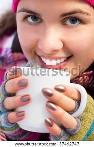 Young beautiful woman holding a cup of coffee (shallow dof)