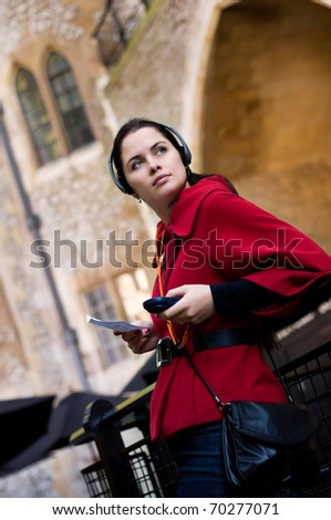 Young woman with headphones, listening to audio guide