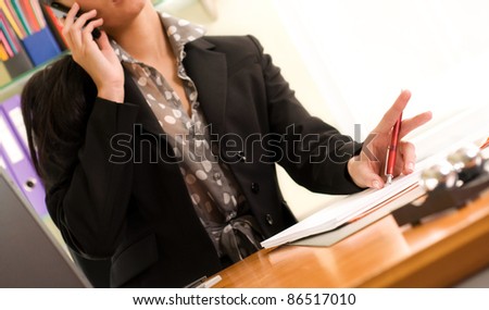 Portrait of a beautiful young businesswoman calling by phone in office