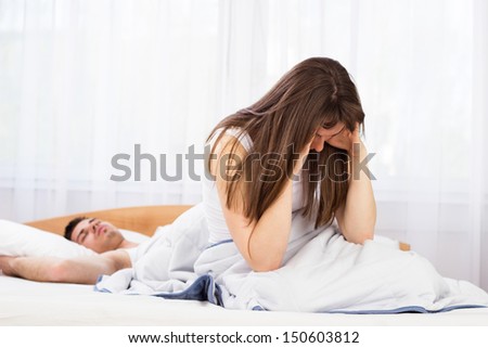 Teenagers problems. Young female sitting looking depressed in bedroom