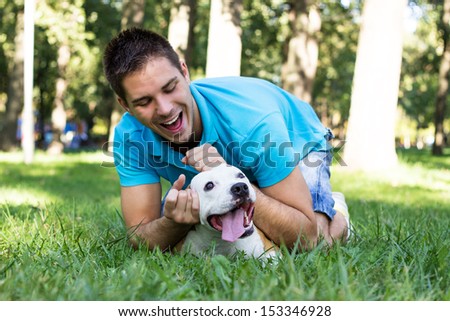 Young man playing with his dog in the park