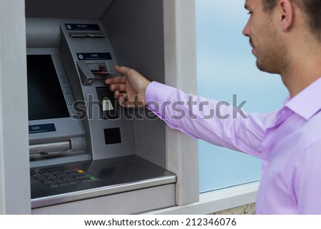 Man takes a credit card from an ATM