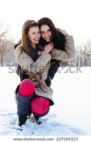 Two best friends hugging in the snow