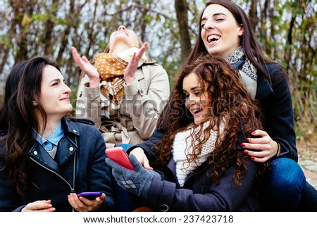 Group of friends with a smartphone, talking and laughing