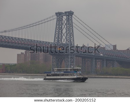 NEW YORK - MAY 22: The East River Ferry passes by the Williamsburg Bridge on May 22nd, 2014 in Williamsburg, Brooklyn. The East River is not a river, but a tidal strait, in New York City.