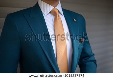 Man in elegant custom tailored expensive suit posing in front of background