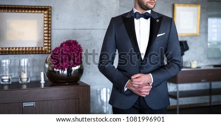 Man in expensive custom tailored tuxedo, suit posing indoors