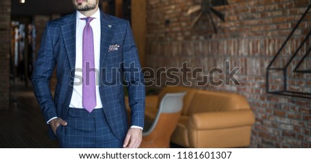 Man in expensive custom tailored suit posing indoors
