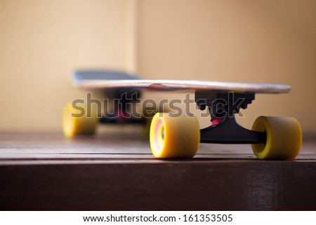 Colorful cruiser skate board with yellow wheels in side angled view