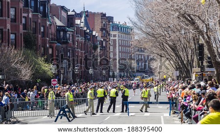 BOSTON - APRIL 21, 2014: Runners in the Boston Marathon approach the finish line surrounded by a clear police presence, a little over a year after the tragic bombings.