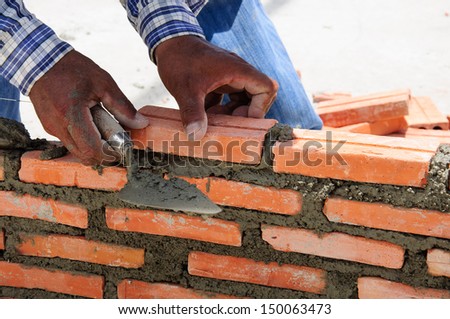 construction mason worker bricklayer installing brick