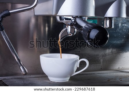 Espresso coffee machine, shot of espresso flowing into a cup.