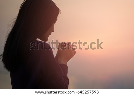 Christian woman praying worship at sunset. Hands folded in prayer. worship god with christian concept religion.