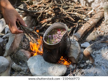 Preparing tea on campfire in wild camping.