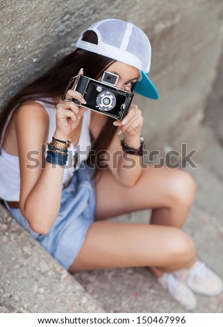 Young, beautiful woman with retro camera. Hipster style. outdoor shot.