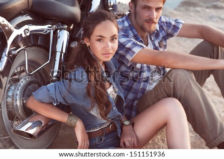 Biker man and girl sits