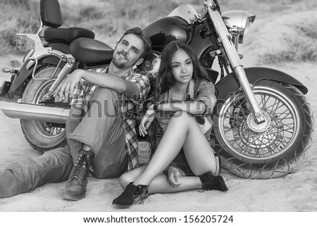Two people and bike - fashion woman and man sitting by motorbike and resting. Adventure and vacations concept
