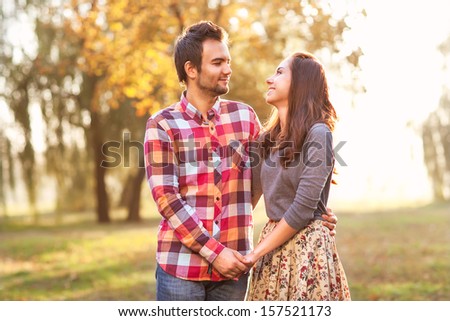 Young couple in love walking in the autumn park near the river.