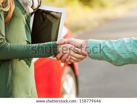 Business handshake to close the deal after buying a car, between a man and a woman