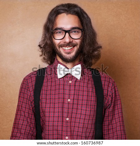 Hipster guy 's clothes in plaid shirt , suspenders and white butterfly . Close up. Studio shot