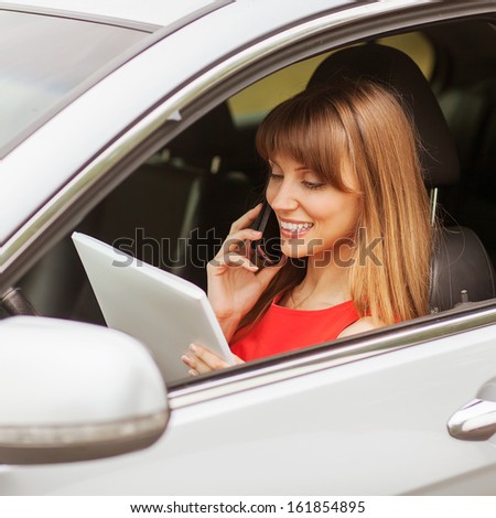 business travel: busy businesswoman with document and laptop in car