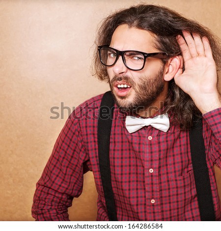 Emotional portrait of a guy who is trying to hear each other, hipster Style, studio shot.