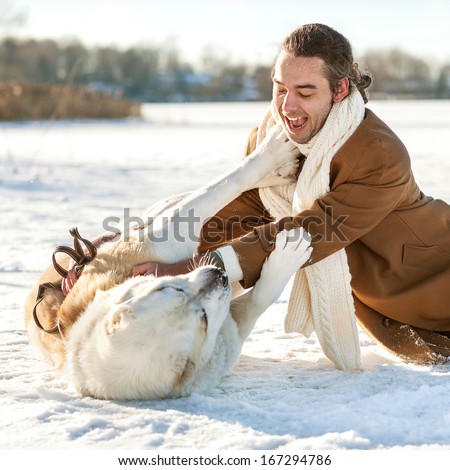 Man and central Asian shepherd  playing with his dog outdoors