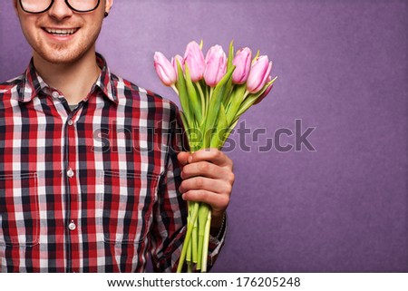 man clothing hipster holding a bouquet of flowers for Valentine's Day concept, mothers day, birthday.
