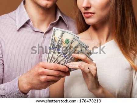 Fashion beautiful couple in love holding money the family budget. Business concept