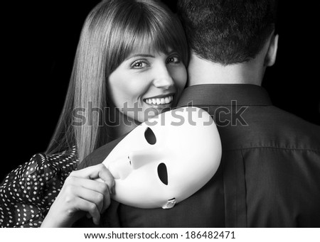 Fashion Happy Couple in Love holding a white mask face. Psychological concept. Duality look at relationships.